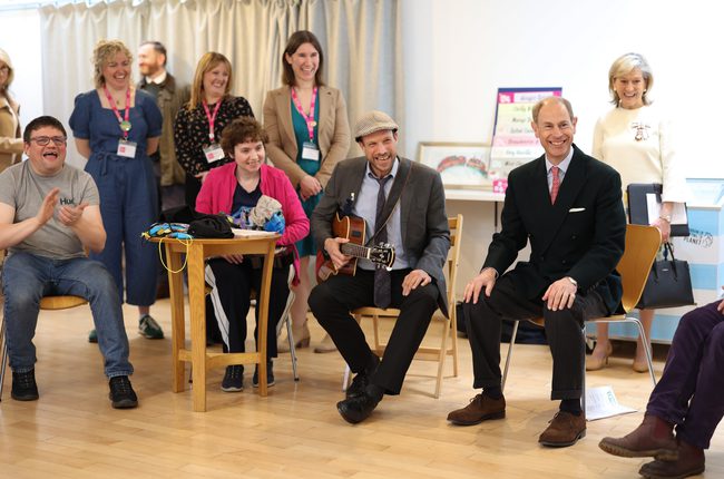HRH The Duke of Edinburgh sits smiling with our Great Company members