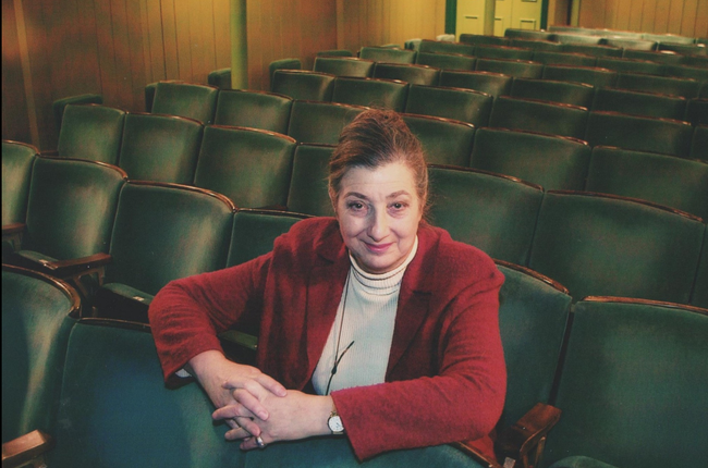 Tamara Malcom sits in the theatre auditorium