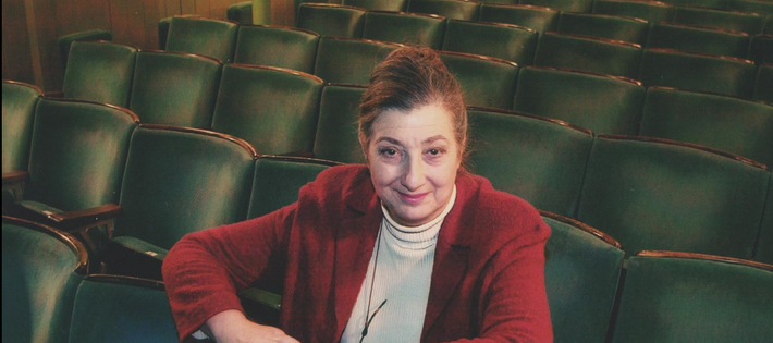 Tamara Malcom sits in the theatre auditorium