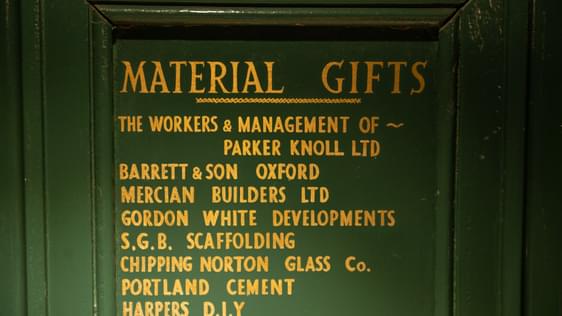 Green board with gold writing listing the material gifts in kind donated when the Theatre was built