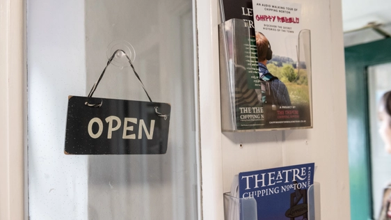 Glass box office door with open sign hanging