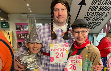 Three people dressed as wizard of Oz characters, Dorothy, Tin Man and Scarecrow