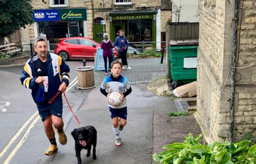 A runner with a dog and a child running with a football