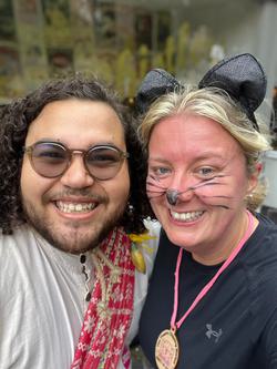 Two people smile for a slefie, one dressed as a mouse