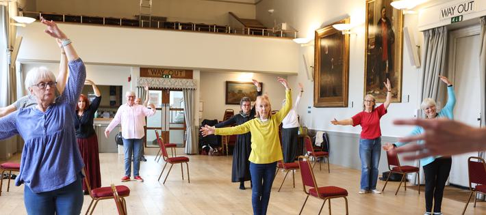 Group dancing with arms held in 4th position