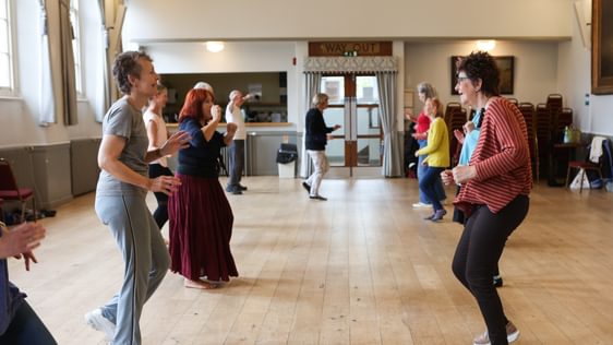 Two lines of people are facing each other as though they are paired up for a dance.