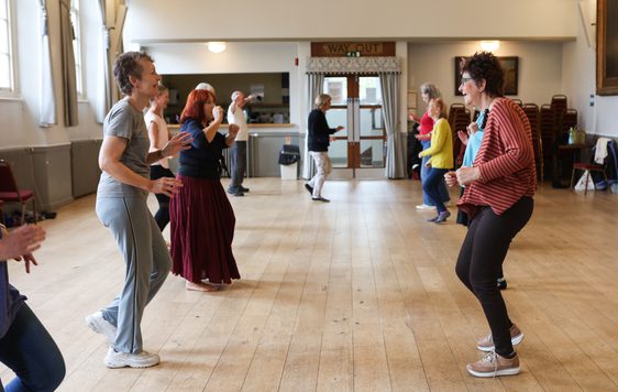 Two lines of people are facing each other as though they are paired up for a dance.