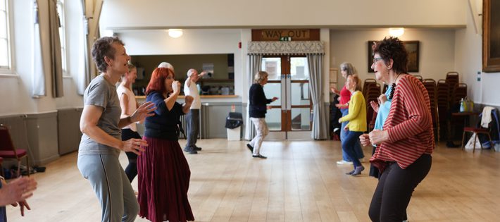 Two lines of people are facing each other as though they are paired up for a dance.