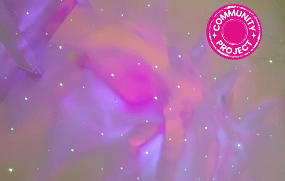 Space lights on ceiling in pink, purple and orange with Community Project badge