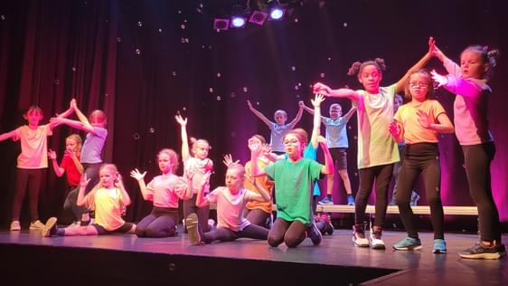 Large group of children on stage at theatre