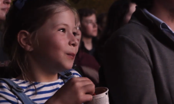 Image of a girl eating popcorn watching the film