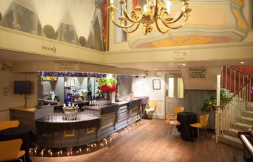 The Theatre bar area showing gold chandelier and murals