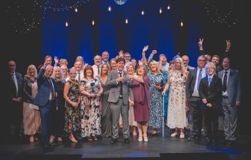 Whole family wedding photo on stage with a mirror ball above