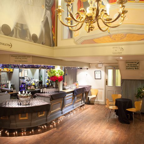The Theatre bar area showing gold chandelier and murals